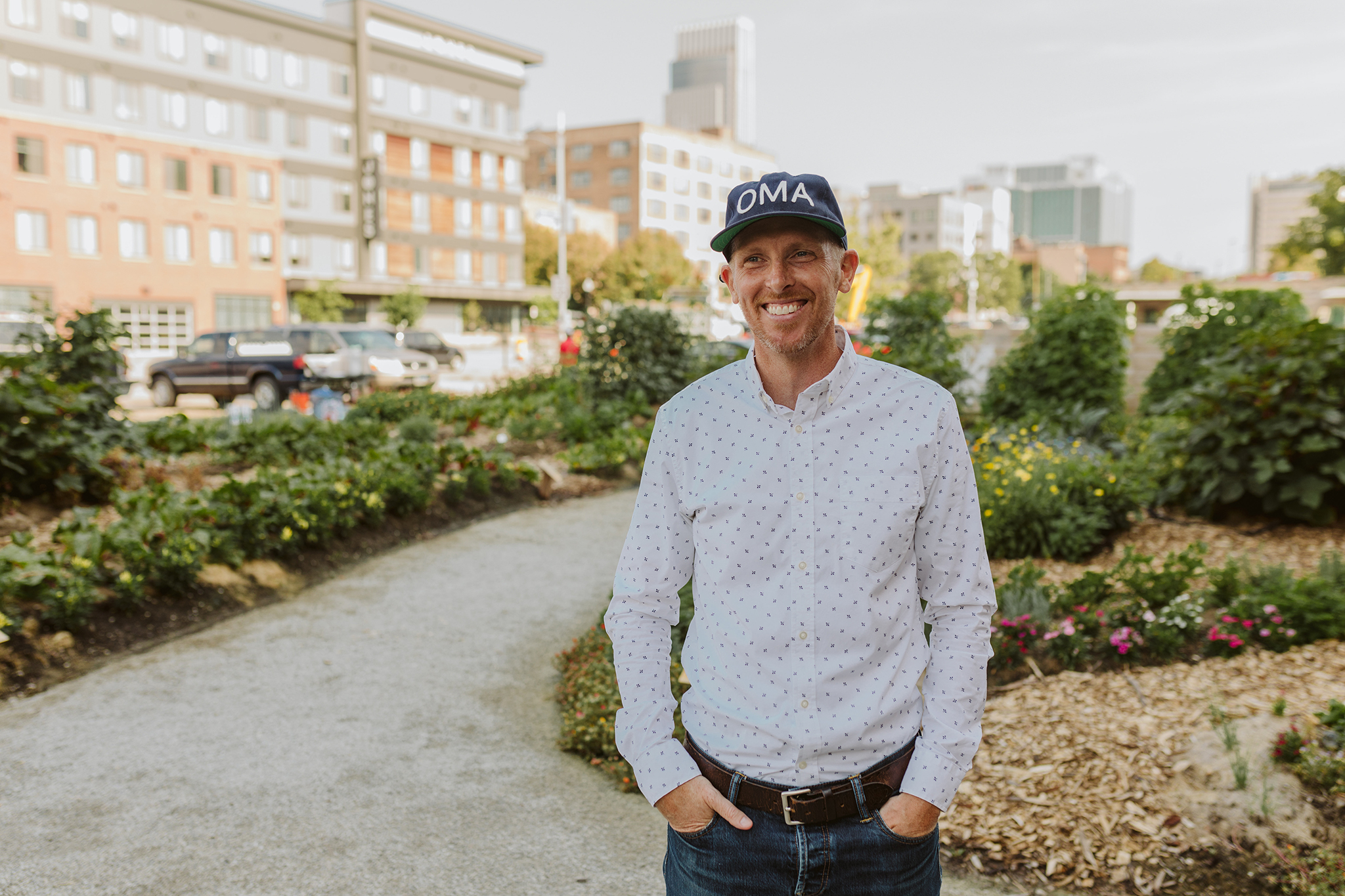 Craig Moody standing in a garden with downtown Omaha in the background