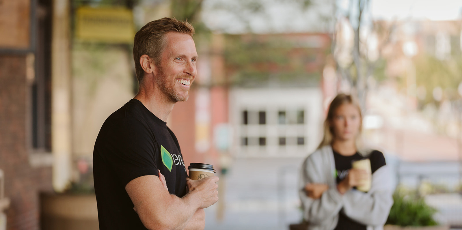 Craig Moody smiling holding a cup of coffee