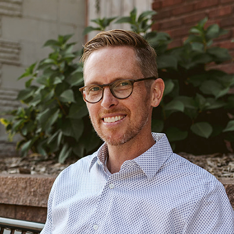 Headshot of Craig Moody sitting on a bench