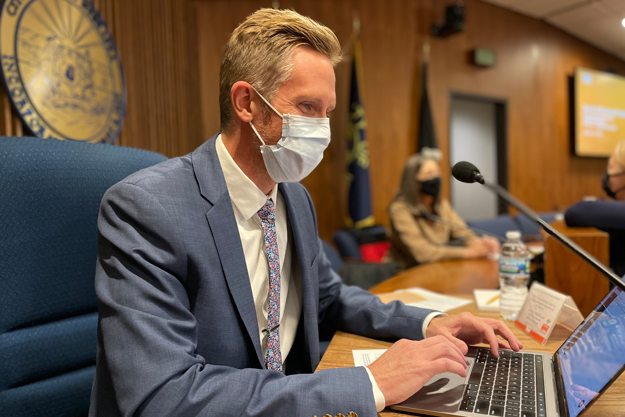 Craig Moody wearing a mask typing on a laptop at an OPPD Meeting